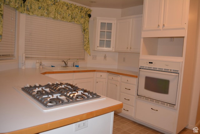 1452 N 3925 W, Marriott Slaterville, UT 84404 - kitchen featuring white appliances, white cabinetry, light countertops, and glass insert cabinets