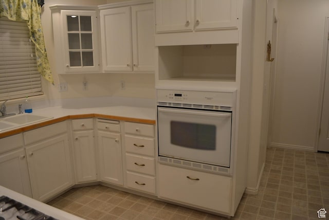 1452 N 3925 W, Marriott Slaterville, UT 84404 - kitchen featuring oven, white cabinetry, light countertops, and glass insert cabinets