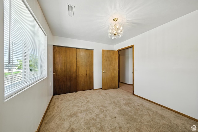 3036 S Dovetail Dr, West Valley City, UT 84128 - unfurnished bedroom featuring light carpet, a chandelier, and a closet