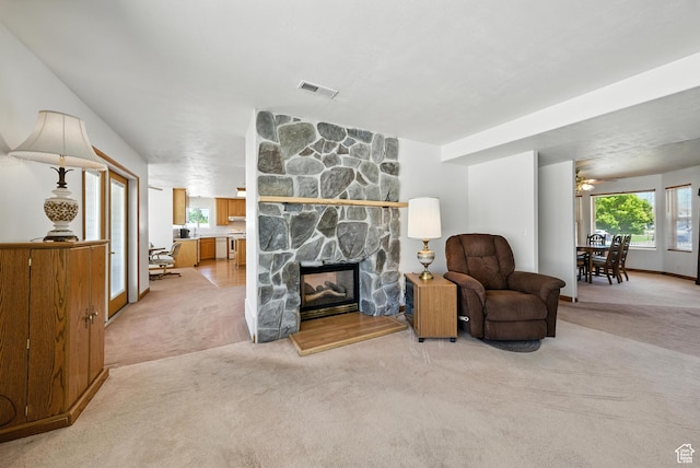 3036 S Dovetail Dr, West Valley City, UT 84128 - living room featuring light colored carpet, ceiling fan, and a fireplace