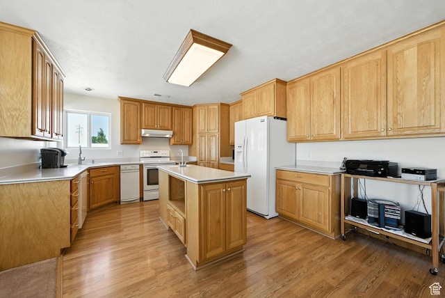 3036 S Dovetail Dr, West Valley City, UT 84128 - kitchen featuring white appliances, light wood-style floors, under cabinet range hood, and an island with sink