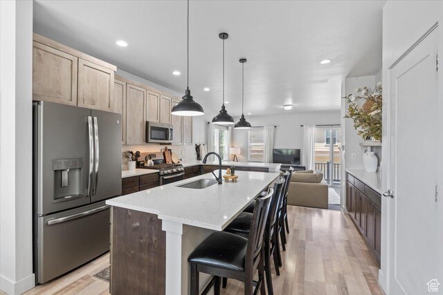 5137 W Stockfield Ln, Herriman, UT 84096 - kitchen featuring appliances with stainless steel finishes, open floor plan, light wood finished floors, light brown cabinets, and recessed lighting