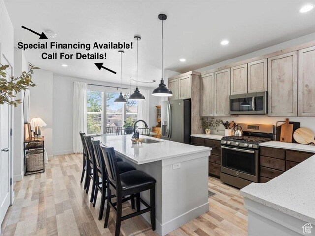 5137 W Stockfield Ln, Herriman, UT 84096 - kitchen featuring appliances with stainless steel finishes, light wood-style flooring, recessed lighting, a kitchen island with sink, and light stone counters