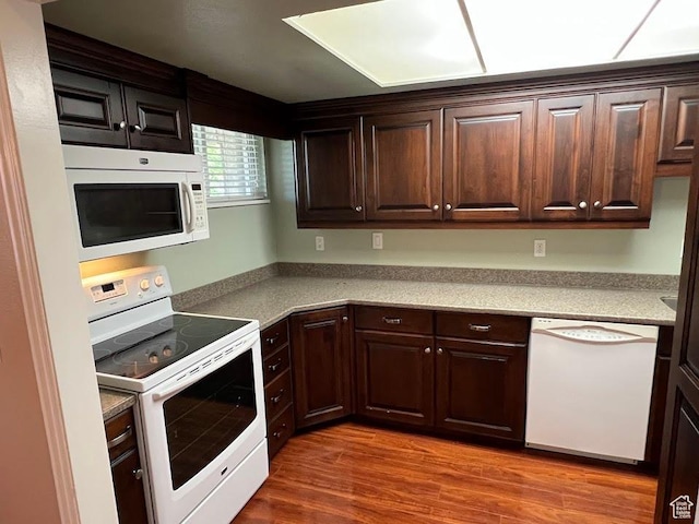 1809 W 7600 S Unit E303, West Jordan, UT 84084 - kitchen with white appliances, dark brown cabinetry, wood finished floors, and light countertops
