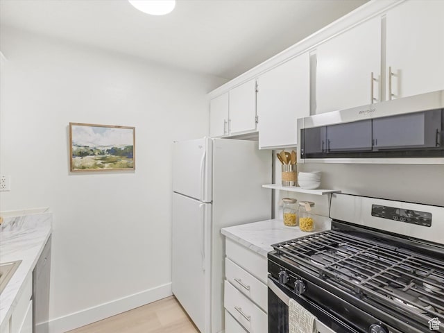 5561 S Willow Ln Unit C, Murray, UT 84107 - kitchen with appliances with stainless steel finishes, light wood-style flooring, white cabinetry, and light stone counters
