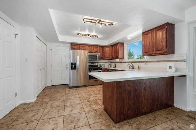 859 E 200 N, Orem, UT 84097 - kitchen with appliances with stainless steel finishes, a tray ceiling, light countertops, a peninsula, and tasteful backsplash