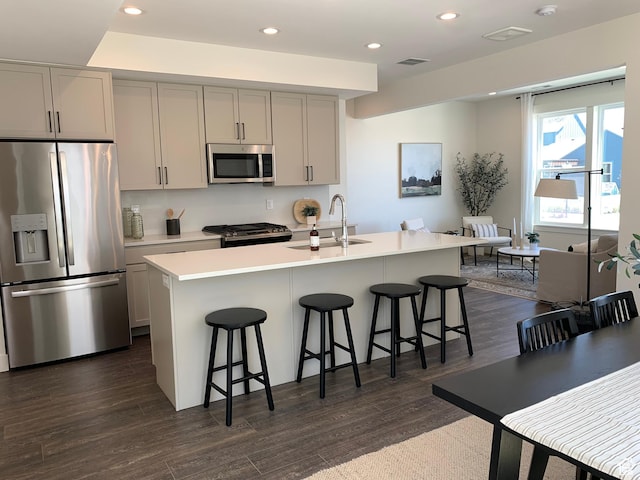 11556 S Watercourse Rd, South Jordan, UT 84009 - kitchen featuring stainless steel appliances, gray cabinetry, dark wood-type flooring, a breakfast bar area, and recessed lighting