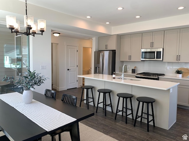 11556 S Watercourse Rd, South Jordan, UT 84009 - kitchen with appliances with stainless steel finishes, gray cabinets, a chandelier, dark wood-style floors, and a breakfast bar area