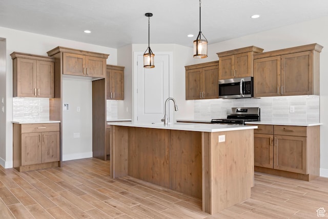 169 N 3670 W, Hurricane, UT 84737 - kitchen with appliances with stainless steel finishes, light wood-style floors, tasteful backsplash, brown cabinets, and light countertops