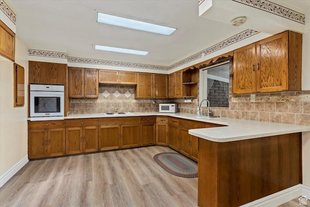 7459 W 3100 S, Magna, UT 84044 - kitchen featuring white appliances, brown cabinetry, open shelves, and light wood-style floors