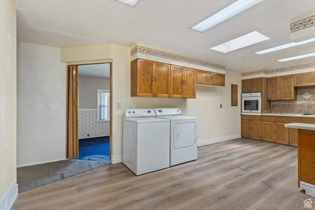 7459 W 3100 S, Magna, UT 84044 - washroom featuring washing machine and dryer, light wood-style floors, and a skylight