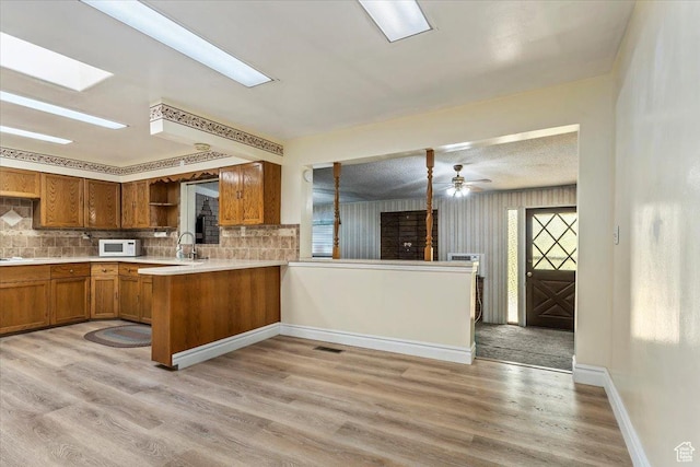 7459 W 3100 S, Magna, UT 84044 - kitchen with white microwave, brown cabinets, open shelves, and tasteful backsplash