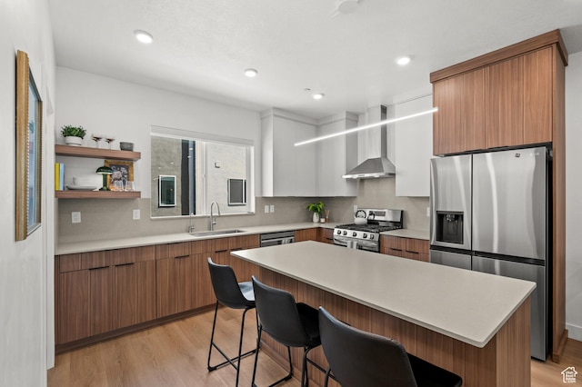765 N 400 W Unit 205, Salt Lake City, UT 84103 - kitchen with stainless steel appliances, wall chimney exhaust hood, a kitchen breakfast bar, light countertops, and light wood-style flooring
