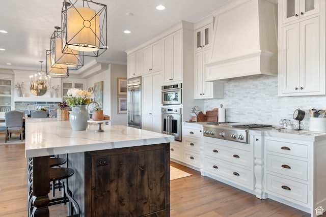 1557 S Stone Cliff Dr, St George, UT 84790 - kitchen with appliances with stainless steel finishes, custom range hood, backsplash, white cabinets, and a center island