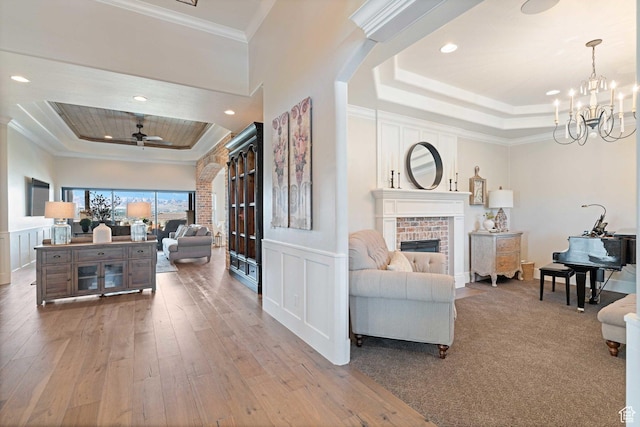 1557 S Stone Cliff Dr, St George, UT 84790 - living area featuring a raised ceiling, ornamental molding, hardwood / wood-style flooring, a fireplace, and a decorative wall