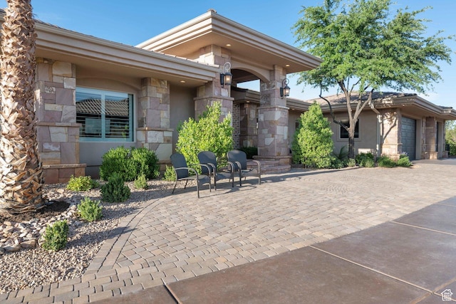 1557 S Stone Cliff Dr, St George, UT 84790 - view of patio featuring a garage and decorative driveway