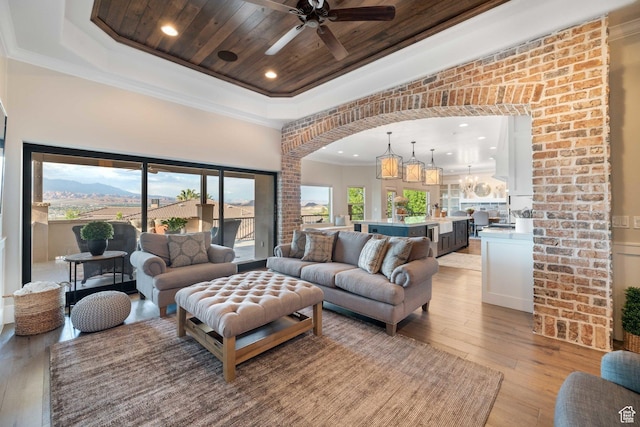 1557 S Stone Cliff Dr, St George, UT 84790 - living room featuring a raised ceiling, a ceiling fan, light wood finished floors, crown molding, and recessed lighting