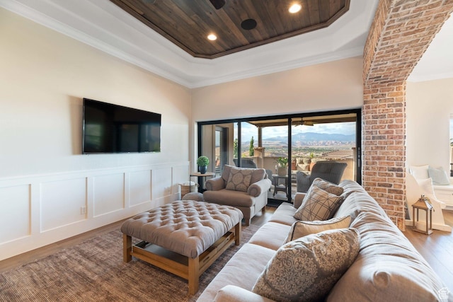 1557 S Stone Cliff Dr, St George, UT 84790 - living room with wood finished floors, a raised ceiling, crown molding, a decorative wall, and wainscoting