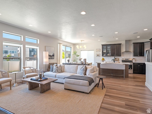 2148 E 970 N, Spanish Fork, UT 84660 - living room with light wood-type flooring, a chandelier, a textured ceiling, and recessed lighting