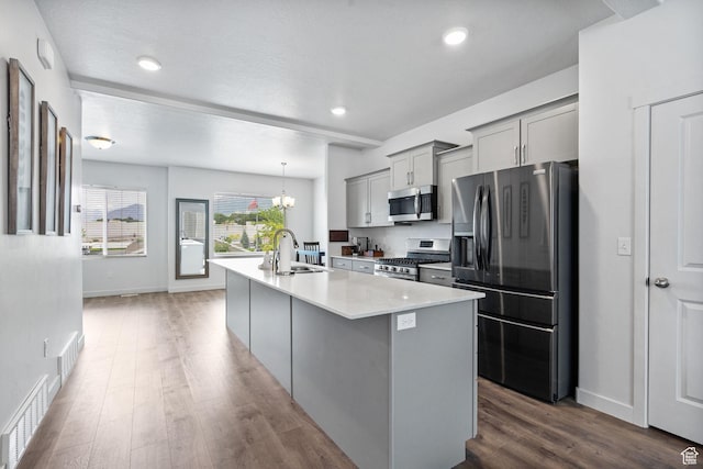 655 W 1430 S, Orem, UT 84058 - kitchen featuring appliances with stainless steel finishes, gray cabinets, light countertops, wood finished floors, and a center island with sink