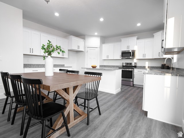 3705 W Chalgrove Rd, Taylor, UT 84401 - kitchen with stainless steel appliances, wood finished floors, recessed lighting, white cabinetry, and a kitchen island