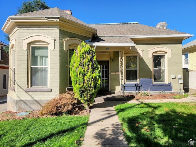 173 N K St E, Salt Lake City, UT 84103 - view of front of home featuring brick siding, a chimney, and roof with shingles