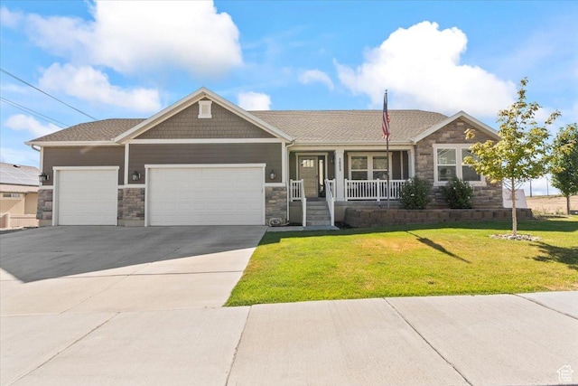 1608 S Terrace Rd, Saratoga Springs, UT 84045 - view of front facade featuring stone siding, a porch, an attached garage, concrete driveway, and a front yard
