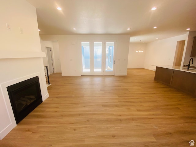 6511 W Lake Ave, South Jordan, UT 84009 - unfurnished living room featuring a fireplace, a chandelier, recessed lighting, and light wood-style flooring