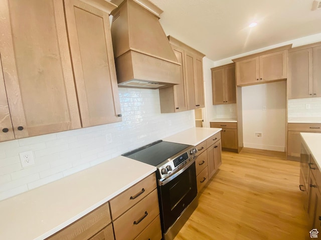 6511 W Lake Ave, South Jordan, UT 84009 - kitchen featuring premium range hood, stainless steel electric range oven, tasteful backsplash, light wood finished floors, and light countertops