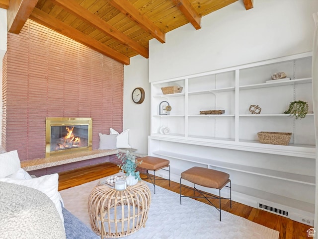 2848 E Loran Heights Dr, Millcreek, UT 84109 - living area with a wood ceiling with exposed beams, wood finished floors, built in features, and a glass covered fireplace
