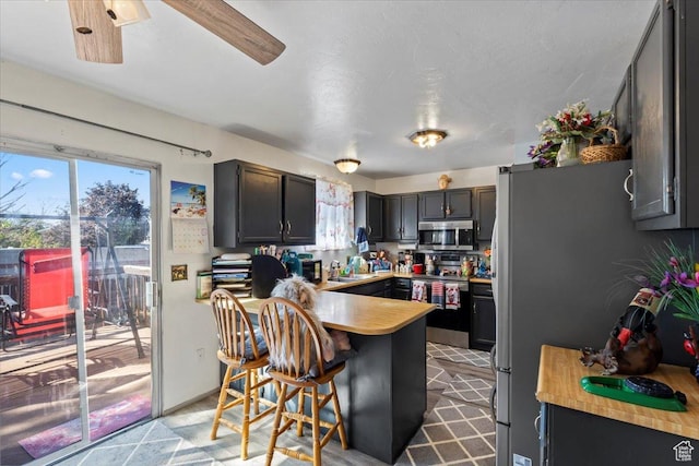 5987 S Salem Cir, Salt Lake City, UT 84118 - kitchen featuring appliances with stainless steel finishes, a peninsula, and a kitchen bar