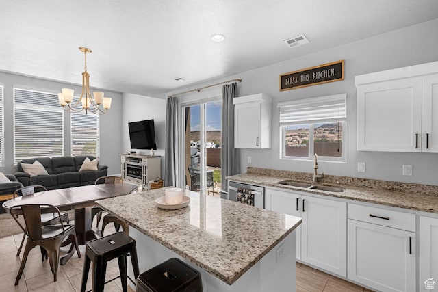 150 N 1100 E Unit 63, Washington, UT 84780 - kitchen featuring a chandelier, white cabinetry, open floor plan, light stone countertops, and decorative light fixtures
