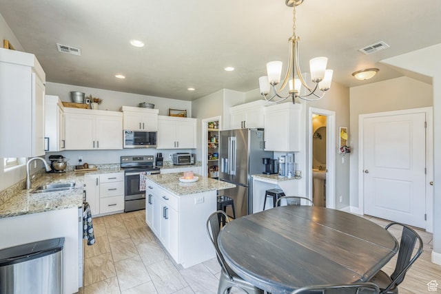 150 N 1100 E Unit 63, Washington, UT 84780 - kitchen with stainless steel appliances, a kitchen island, white cabinets, a chandelier, and recessed lighting