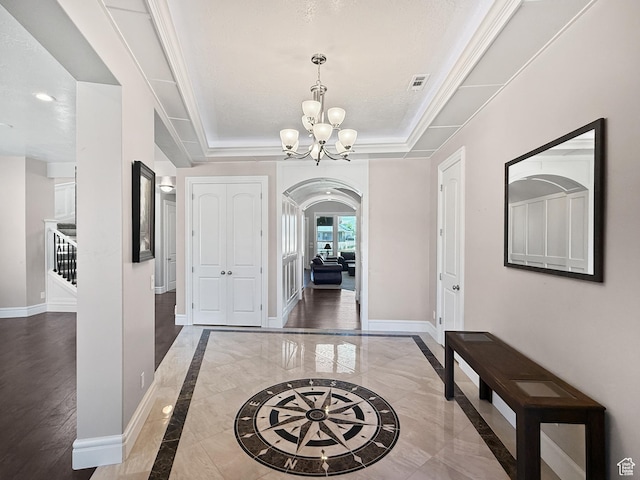 1645 E 6800 S, Uintah, UT 84405 - foyer entrance with arched walkways, a chandelier, a tray ceiling, inlaid floor details, and ornamental molding