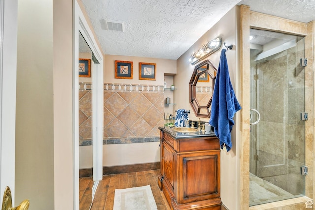 1120 E Yale Ave, Salt Lake City, UT 84105 - full bathroom featuring vanity, wood finished floors, a textured ceiling, and a stall shower