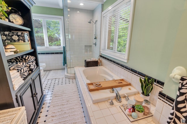 1120 E Yale Ave, Salt Lake City, UT 84105 - full bath with a stall shower, a tub with jets, healthy amount of natural light, tile patterned floors, and tile walls