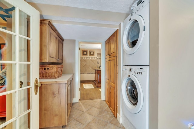 1120 E Yale Ave, Salt Lake City, UT 84105 - laundry area featuring cabinet space, estacked washer and dryer, and light tile patterned floors