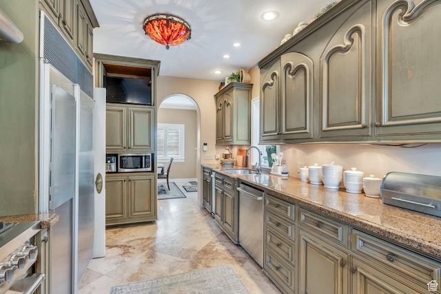 1120 E Yale Ave, Salt Lake City, UT 84105 - kitchen featuring appliances with stainless steel finishes, arched walkways, light stone countertops, and recessed lighting