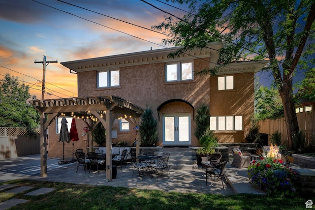 1120 E Yale Ave, Salt Lake City, UT 84105 - back of property at dusk featuring french doors, a pergola, stucco siding, a patio area, and outdoor lounge area