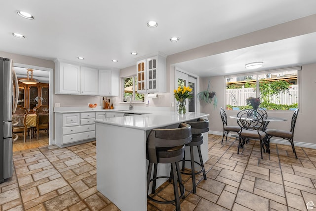3491 S Monte Verde Dr E, Millcreek, UT 84109 - kitchen with freestanding refrigerator, a peninsula, a kitchen breakfast bar, recessed lighting, and light countertops