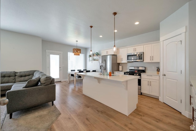 3781 W 2330 N, Lehi, UT 84043 - kitchen with stainless steel appliances, open floor plan, a breakfast bar, white cabinets, and recessed lighting