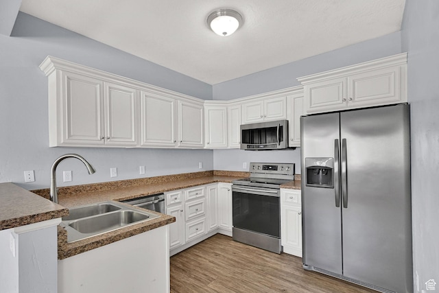 1568 N 565 W Unit 104, Logan, UT 84341 - kitchen with stainless steel appliances, light wood-style flooring, a peninsula, and white cabinets