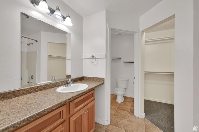 1568 N 565 W Unit 104, Logan, UT 84341 - full bathroom featuring a walk in closet, vanity, tile patterned flooring, and a shower