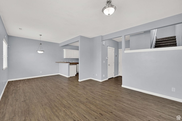 1568 N 565 W Unit 104, Logan, UT 84341 - unfurnished living room featuring dark wood finished floors and stairway