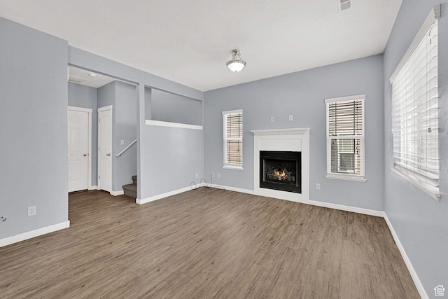 1568 N 565 W Unit 104, Logan, UT 84341 - unfurnished living room with wood finished floors, a warm lit fireplace, and stairs