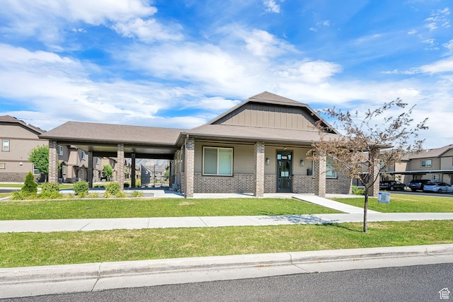 1568 N 565 W Unit 104, Logan, UT 84341 - view of front of house with a front yard, brick siding, covered porch, and board and batten siding