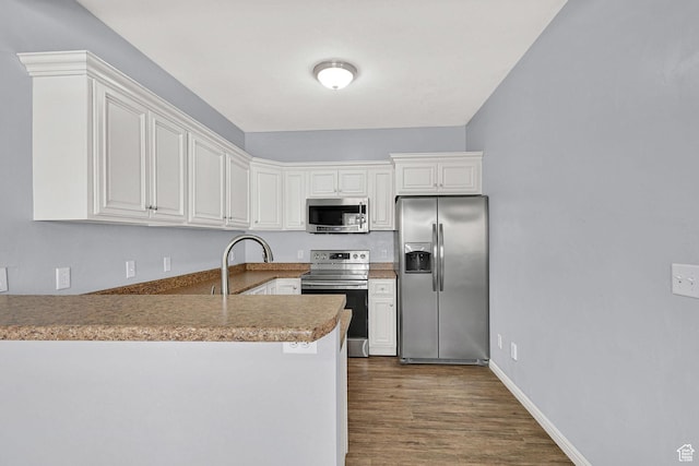 1568 N 565 W Unit 104, Logan, UT 84341 - kitchen featuring stainless steel appliances, a peninsula, dark wood finished floors, and white cabinetry