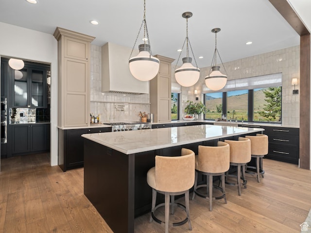 322 S 7900th St E Unit 5, Huntsville, UT 84317 - kitchen featuring custom range hood, a center island, backsplash, light wood-style floors, and a kitchen bar