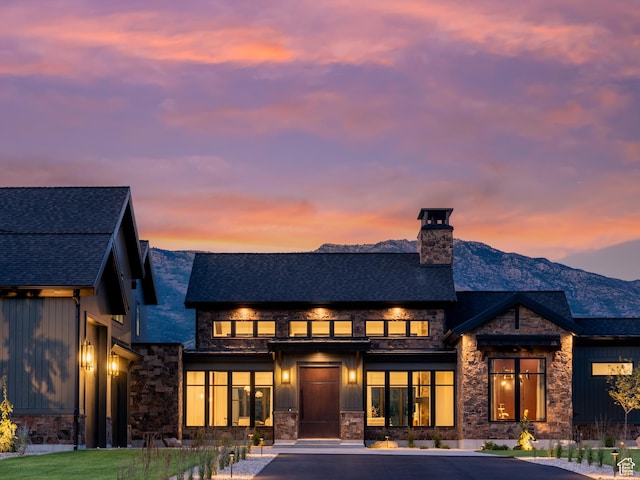 322 S 7900th St E Unit 5, Huntsville, UT 84317 - back of house at dusk with stone siding, a chimney, a shingled roof, and board and batten siding
