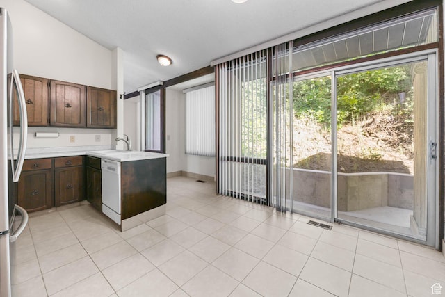 3574 E Kings Cove Way, Cottonwood Heights, UT 84121 - kitchen featuring light countertops, dishwasher, freestanding refrigerator, a peninsula, and light tile patterned floors